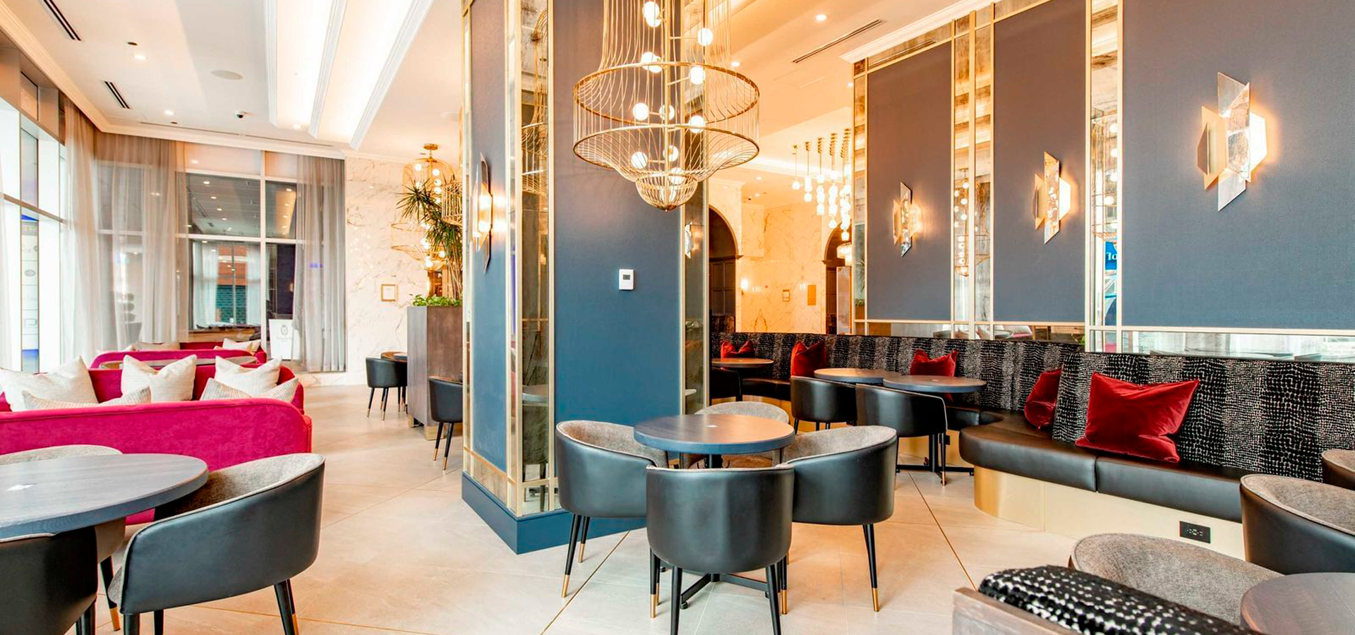 A lobby area with couches and tables, as well as beautiful chandeliers